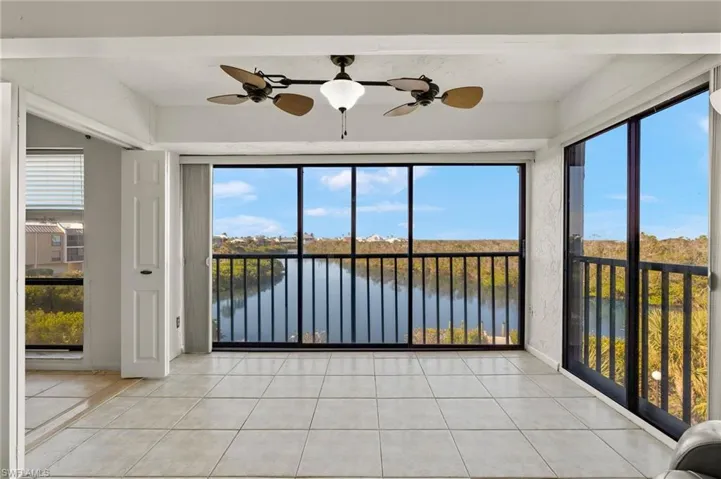 Unfurnished sunroom with ceiling fan, plenty of natural light, and a water view
