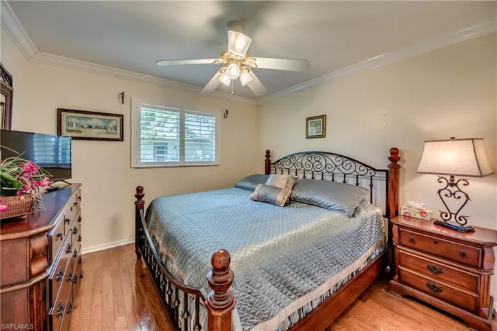 Bedroom featuring ceiling fan, crown molding, and hardwood / wood-style flooring