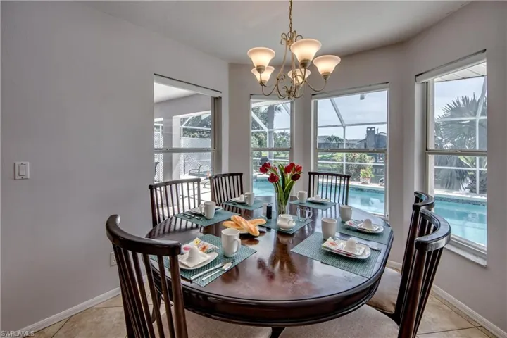 Tiled dining space featuring a notable chandelier