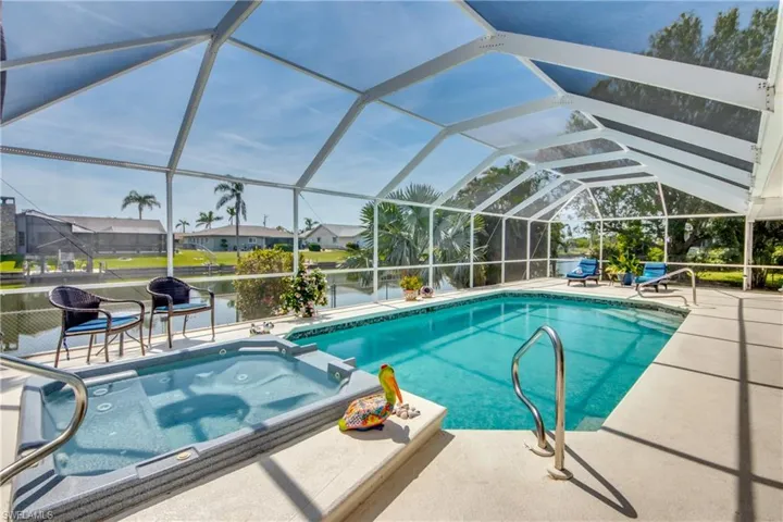 View of pool featuring an in ground hot tub, a patio, and glass enclosure