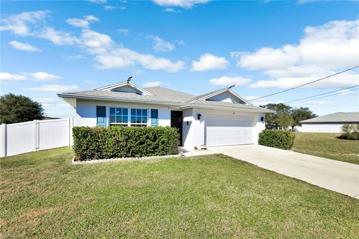 Ranch-style house with stucco siding, an attached garage, and driveway