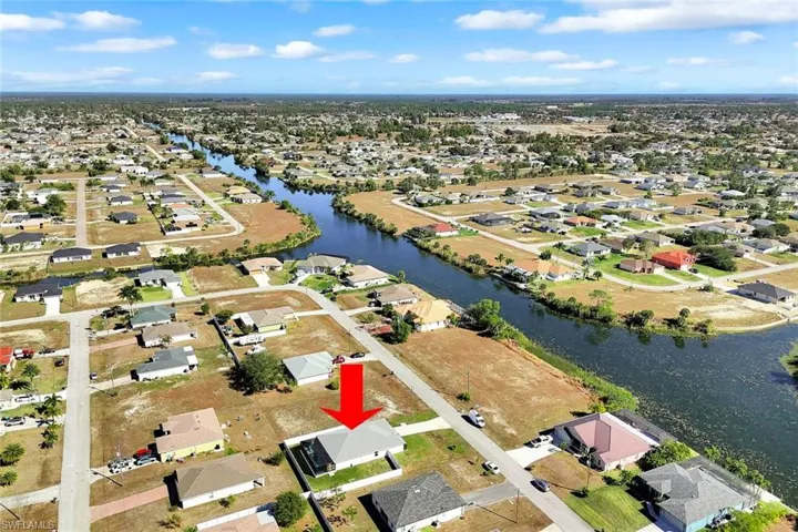 Aerial view of property and surrounding area with nearby suburban area