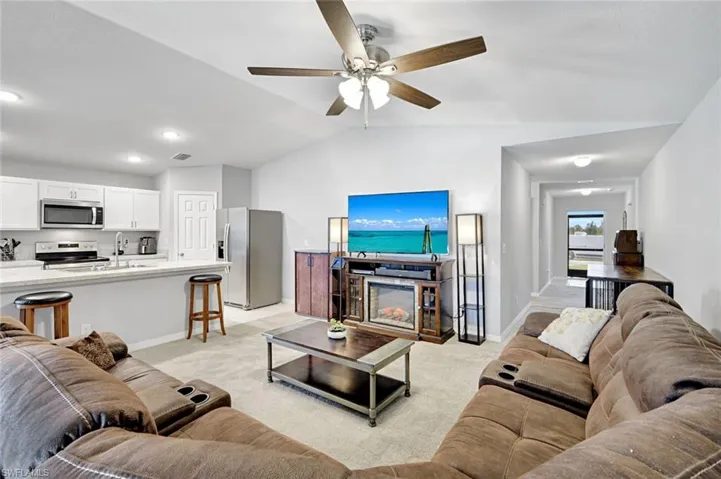 Living area with light colored carpet and ceiling fan