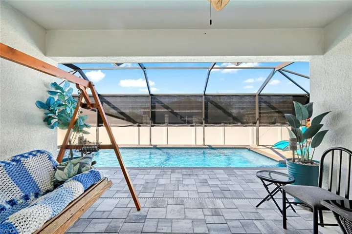 Swimming pool with a patio, a sunroom, and a lanai