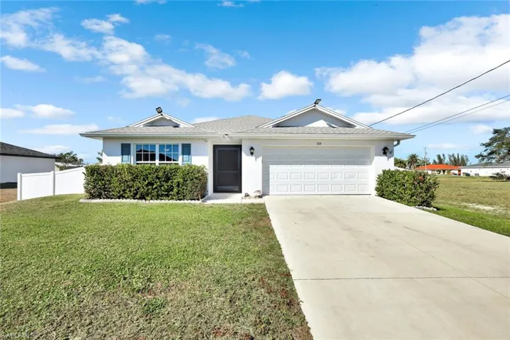 Ranch-style home featuring stucco siding, a garage, and concrete driveway