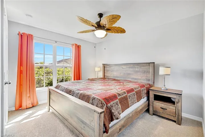 Carpeted bedroom featuring baseboards and a ceiling fan
