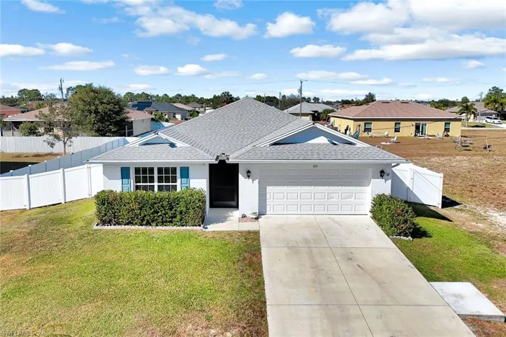 Ranch-style house featuring a residential view, a shingled roof, concrete driveway, and stucco siding