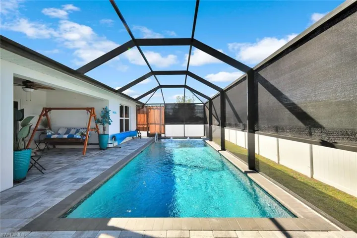 Outdoor pool featuring a sunroom, a lanai, and a patio area