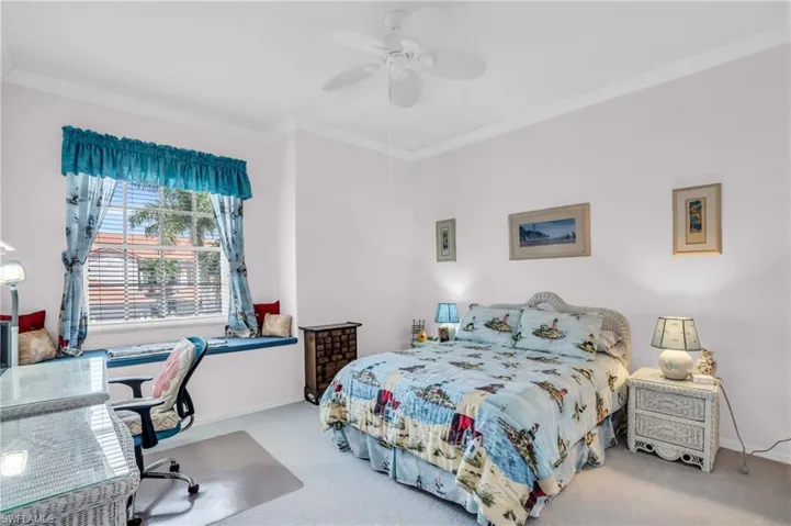 Carpeted bedroom with ceiling fan and ornamental molding