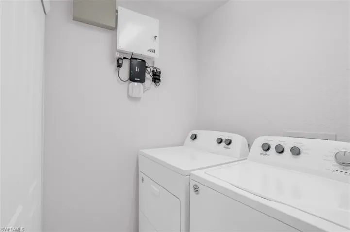 Laundry area featuring tankless water heater and washer and clothes dryer