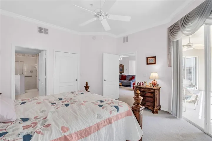 Bedroom with ensuite bath, light carpet, ceiling fan, and ornamental molding
