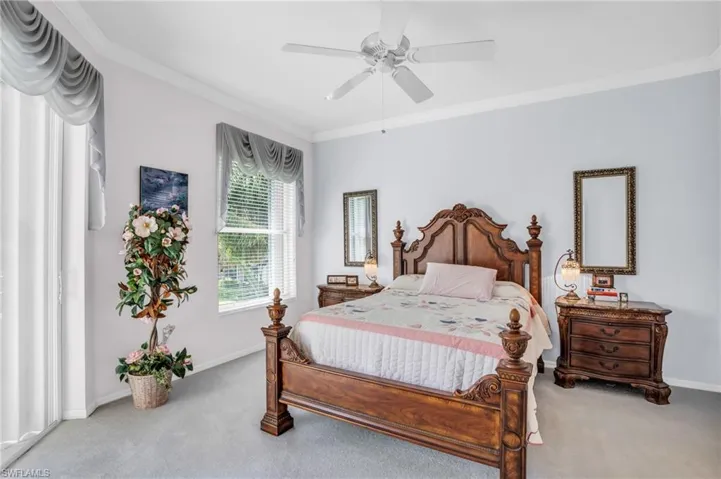 Carpeted bedroom featuring crown molding and ceiling fan