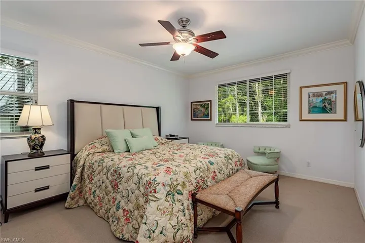 Carpeted bedroom featuring crown molding and a ceiling fan