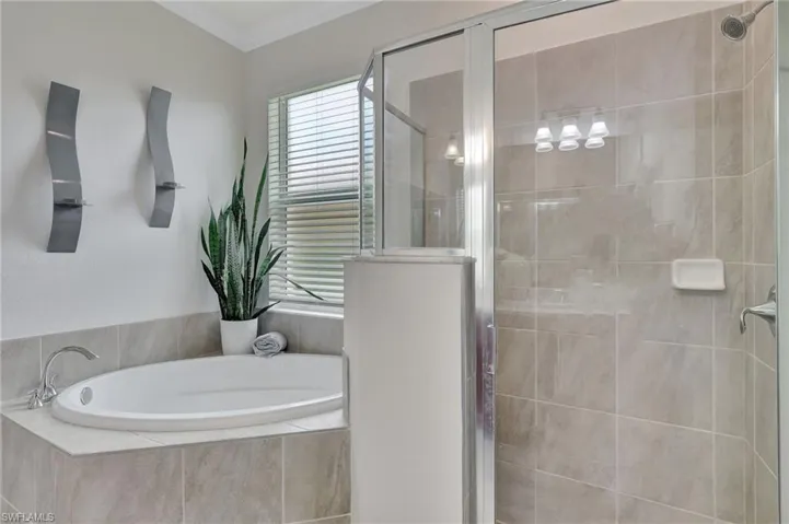 Bathroom featuring shower with separate bathtub and ornamental molding