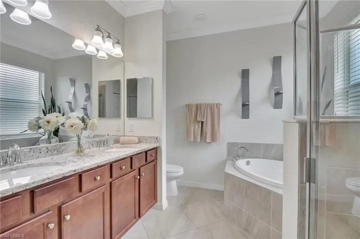 Full bathroom featuring ornamental molding, toilet, tile patterned floors, and double sink vanity