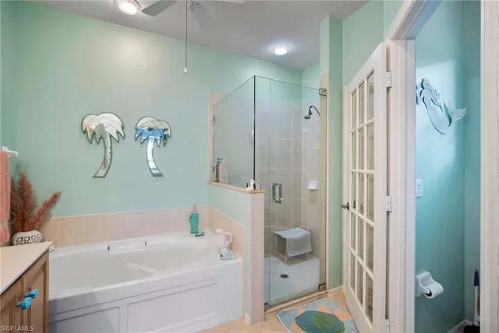 Bathroom featuring vanity, shower with separate bathtub, tile patterned floors, and ceiling fan