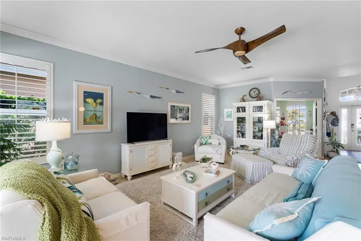 Living room featuring rug, a healthy amount of sunlight, and ceiling fan