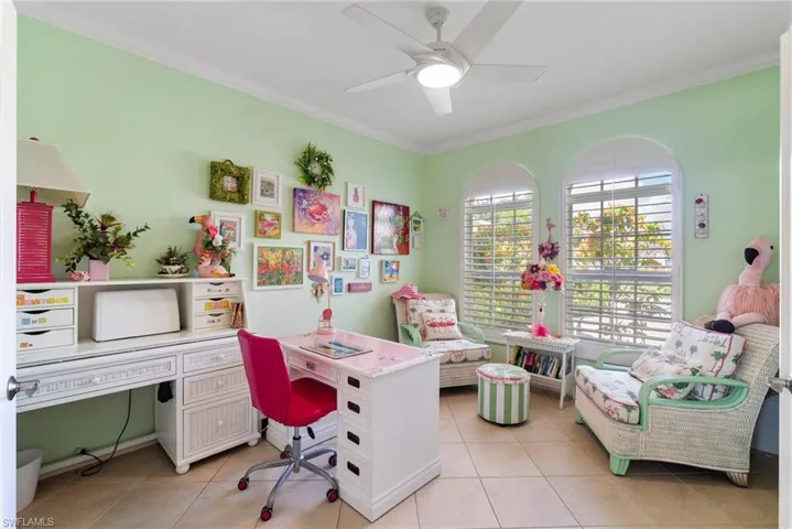 Tiled office space featuring ceiling fan and crown molding