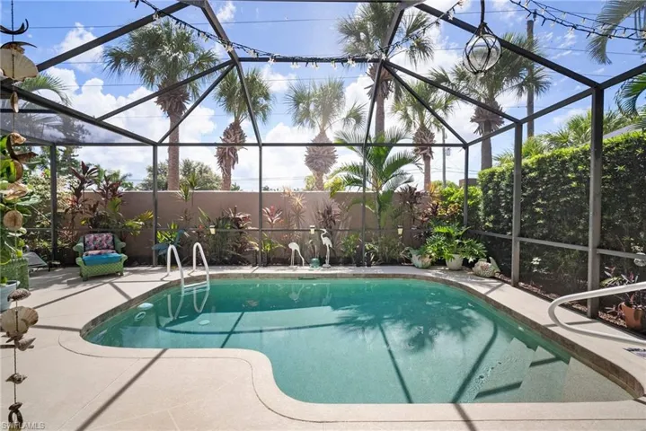 View of swimming pool featuring a patio area and glass enclosure