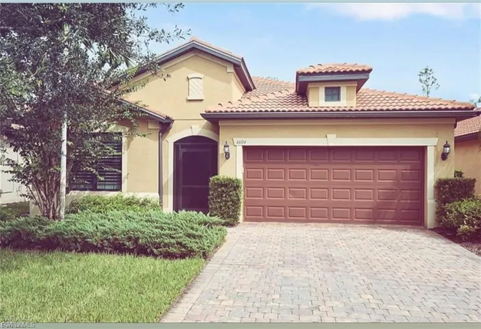 Mediterranean / spanish home with decorative driveway, stucco siding, a garage, and a tiled roof