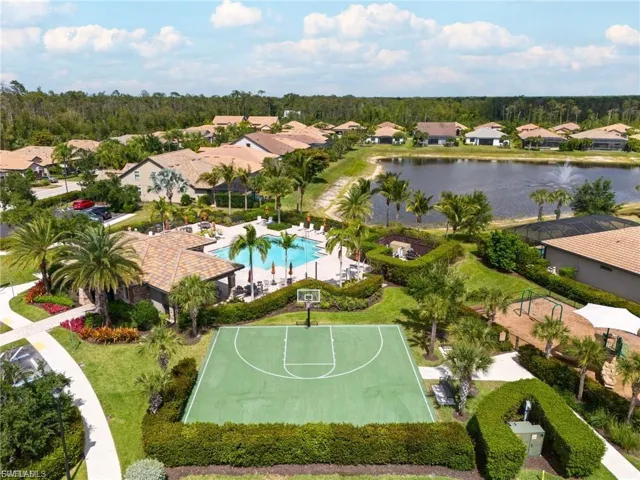 Aerial perspective of suburban area featuring a large body of water and a pool area