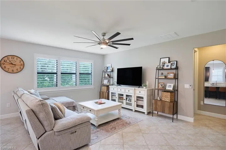 Living area with ceiling fan and light tile patterned floors