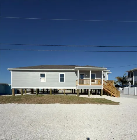 Coastal home with covered porch and a shingled roof