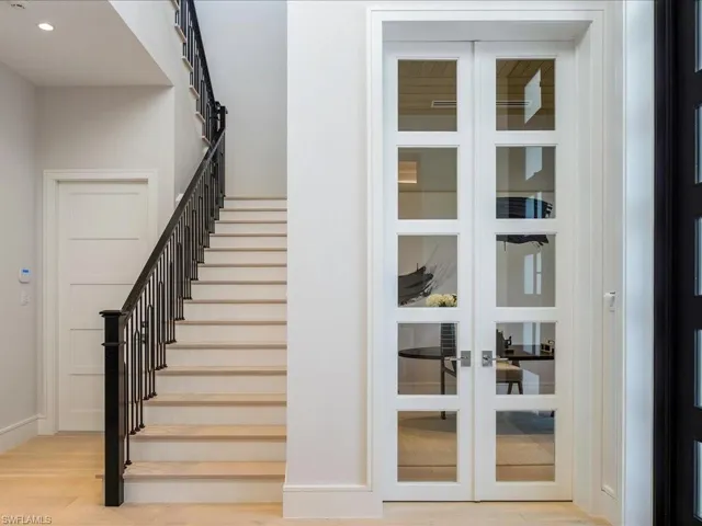 Staircase featuring french doors, recessed lighting, baseboards, and wood finished floors