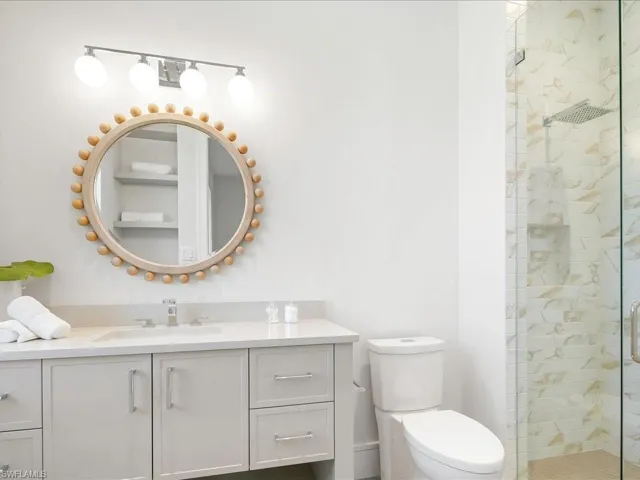 Full bath featuring toilet, vanity, and a shower stall