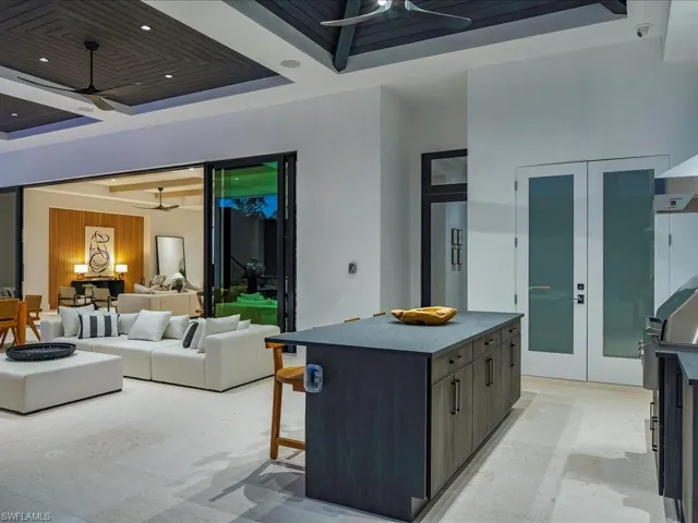 Kitchen featuring a kitchen breakfast bar, recessed lighting, a raised ceiling, a kitchen island, and a ceiling fan