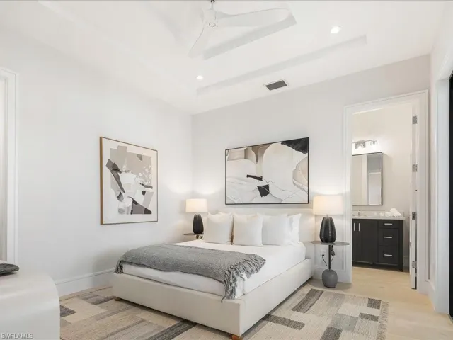Bedroom featuring visible vents, baseboards, recessed lighting, a raised ceiling, and light wood-style floors