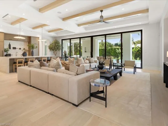 Living area with beamed ceiling, baseboards, recessed lighting, a ceiling fan, and light wood-type flooring