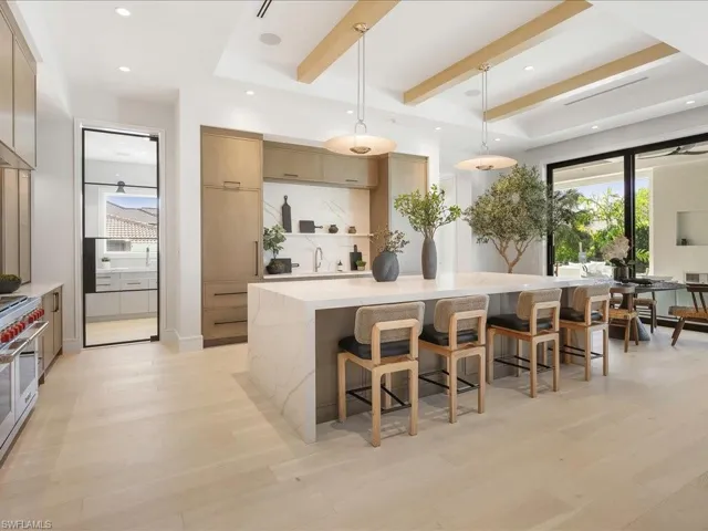 Kitchen with double oven range, modern cabinets, beamed ceiling, and light wood finished floors