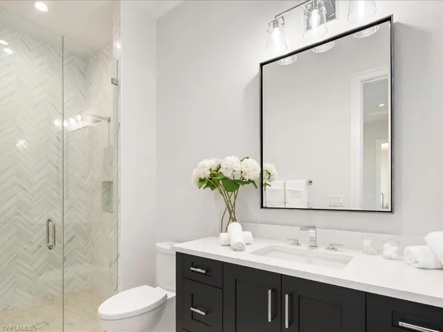 Full bath featuring toilet, vanity, and a shower stall