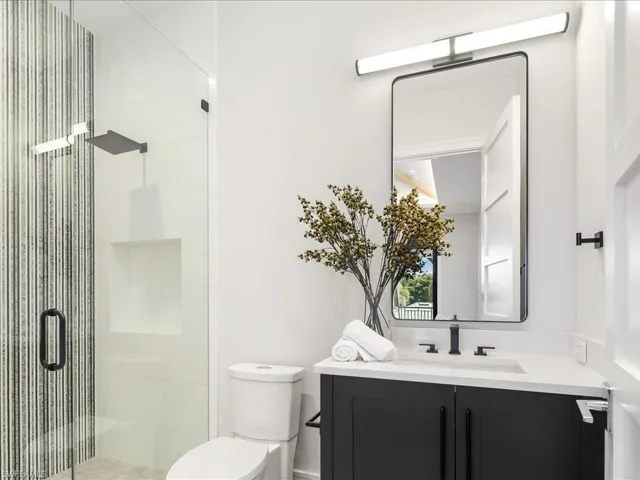 Full bathroom featuring toilet, a stall shower, and vanity