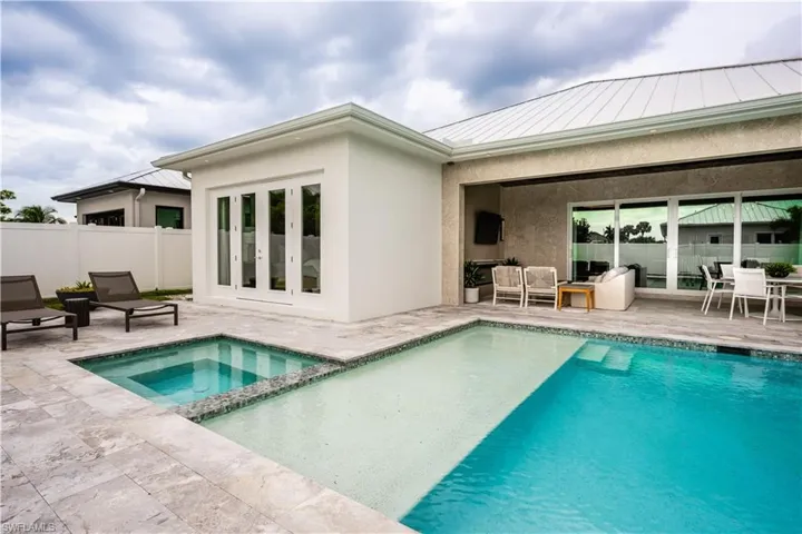 View of swimming pool featuring a patio area, french doors, a pool with connected hot tub, and outdoor lounge area