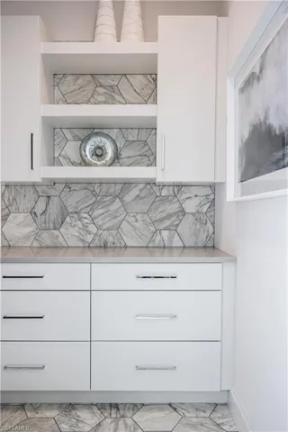 Kitchen view of white cabinetry, open shelves, and modern cabinets