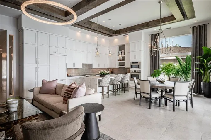 Kitchen featuring dark stone countertops, white cabinetry, wine cooler, decorative backsplash, and recessed lighting