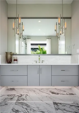 Bathroom featuring vanity, marble finish floors, and a chandelier