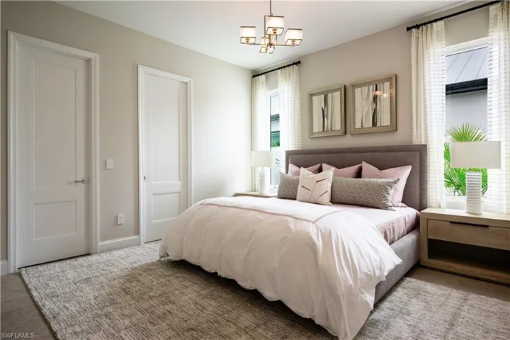Carpeted bedroom featuring a chandelier and baseboards