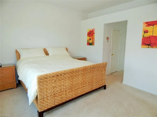 Bedroom with light colored carpet and baseboards