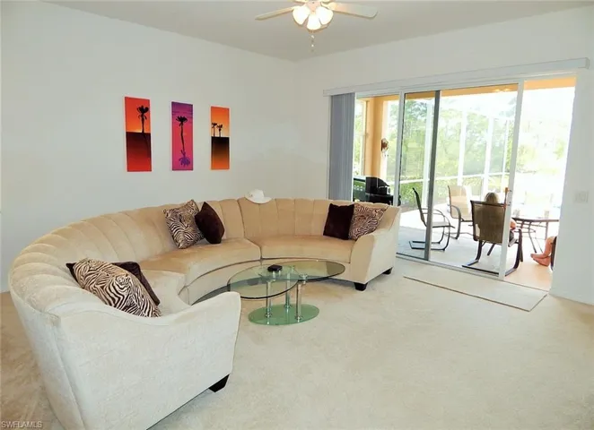 Living area featuring ceiling fan and carpet