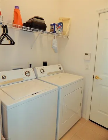 Washroom featuring independent washer and dryer and light tile patterned floors