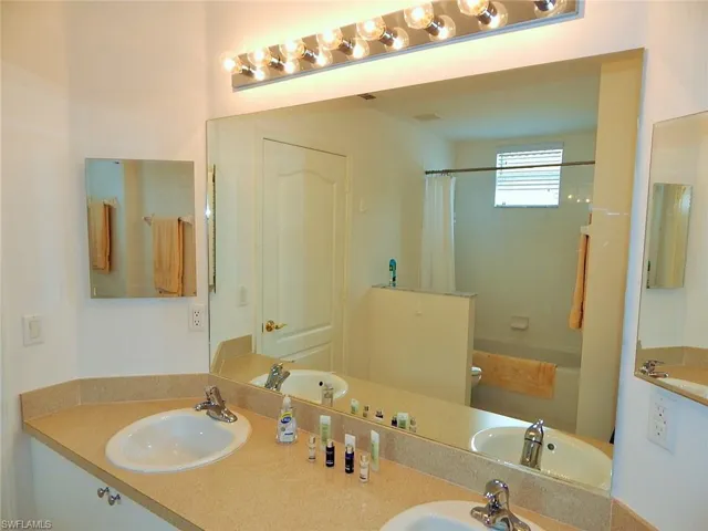 Bathroom with double vanity and shower / tub combo