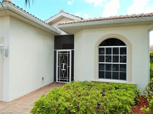 Entrance to property with stucco siding and a tile roof