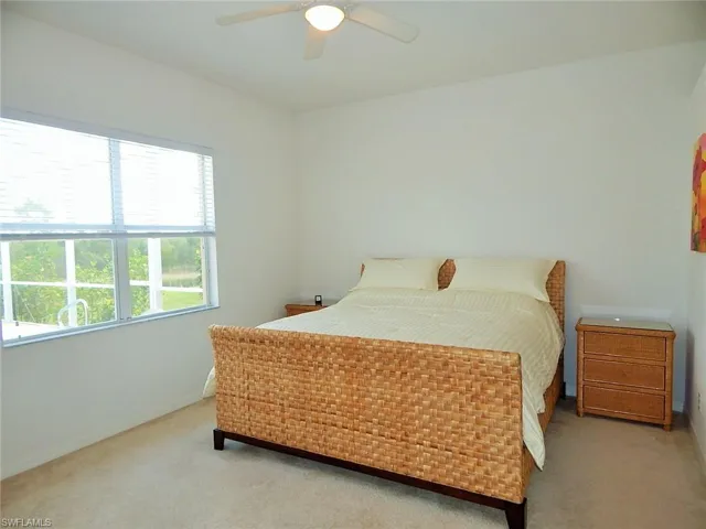 Carpeted bedroom featuring ceiling fan and baseboards