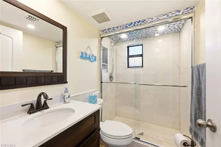Full bath featuring a stall shower and vanity