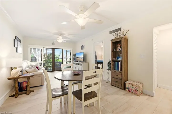 Dining space featuring crown molding, light wood-type flooring, and a ceiling fan