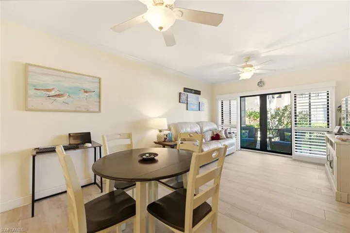 Dining area featuring french doors, crown molding, light wood-style flooring, and a ceiling fan