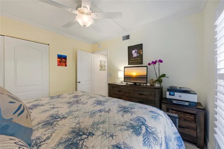 Bedroom with crown molding, a closet, and a ceiling fan